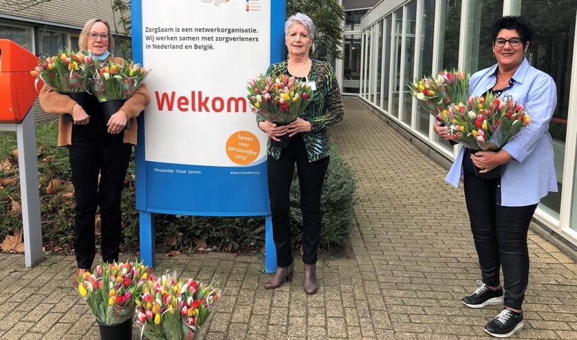 <p>Twee gastvrouwen van ZorgSaam nemen een deel van de tulpen in ontvangst van een medewerkster van Vegro.</p>  