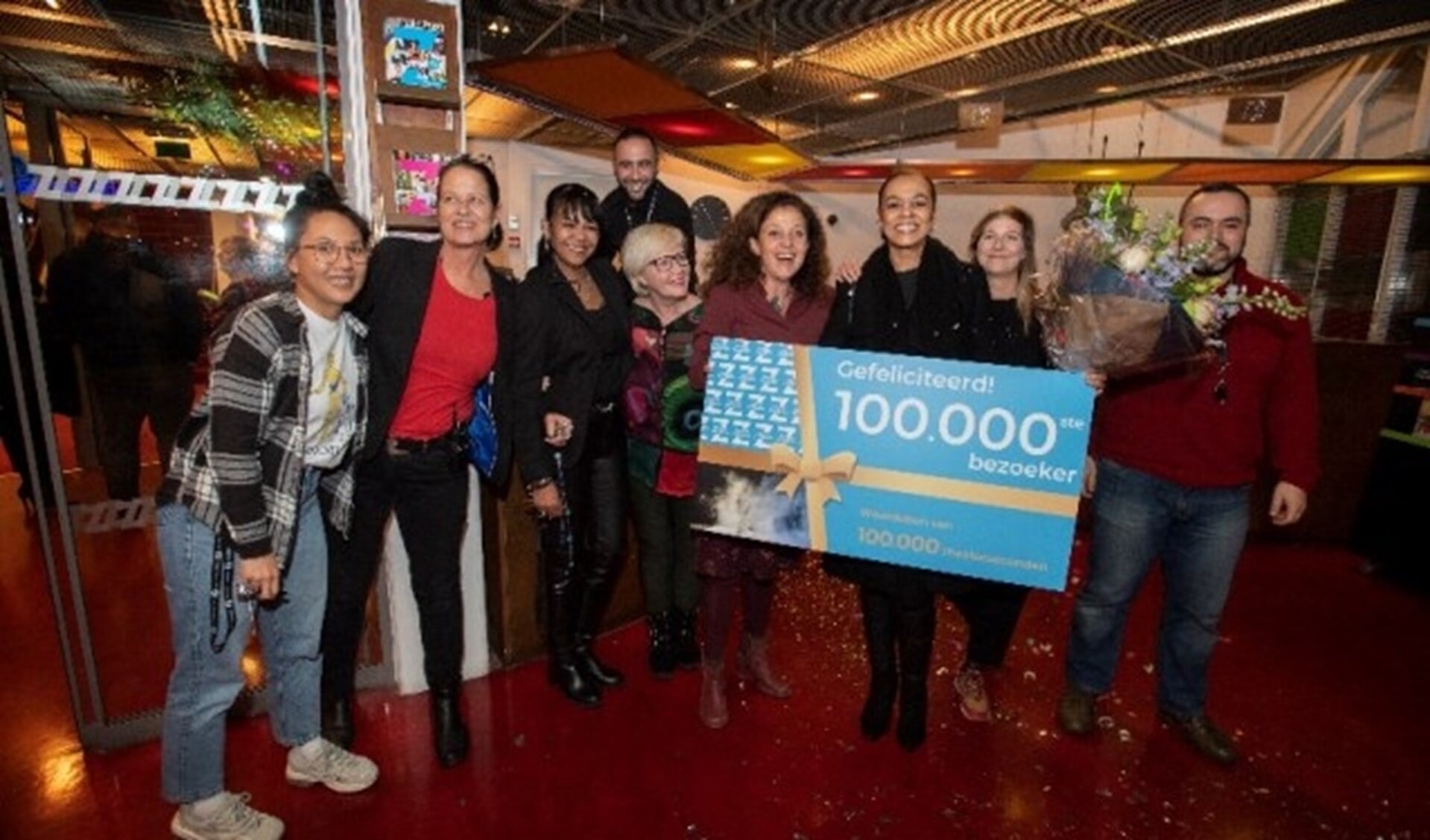 Directeur en medewerkers Theater Zuidplein op de foto met de 100.000ste bezoeker. 