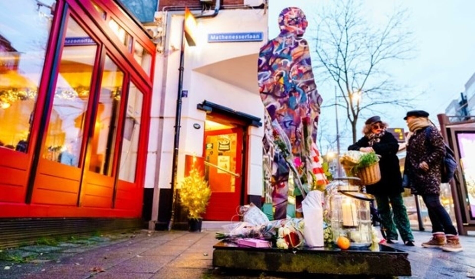 Sinds donderdag laten mensen bloemen achter bij het beeld van Deelder bij café Ari.