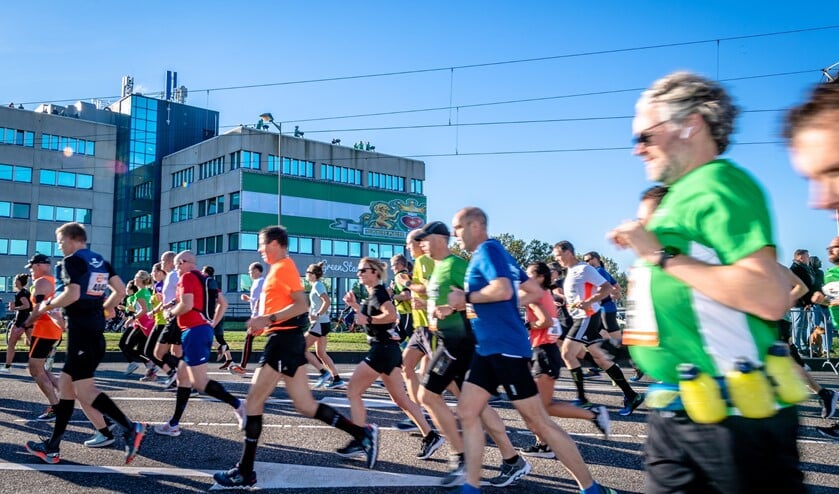 Rotterdamse aanvoerders juichen marathonlopers toe vanaf dakterras. Foto: Jan Kok
