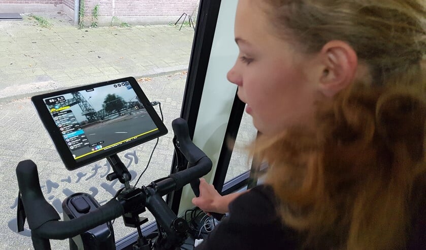 Roos van den Berg heeft flink doorgetrapt tijdens haar halfuurtje op de racefiets in de speciaal ingerichte container. Foto: Emile Hilgers