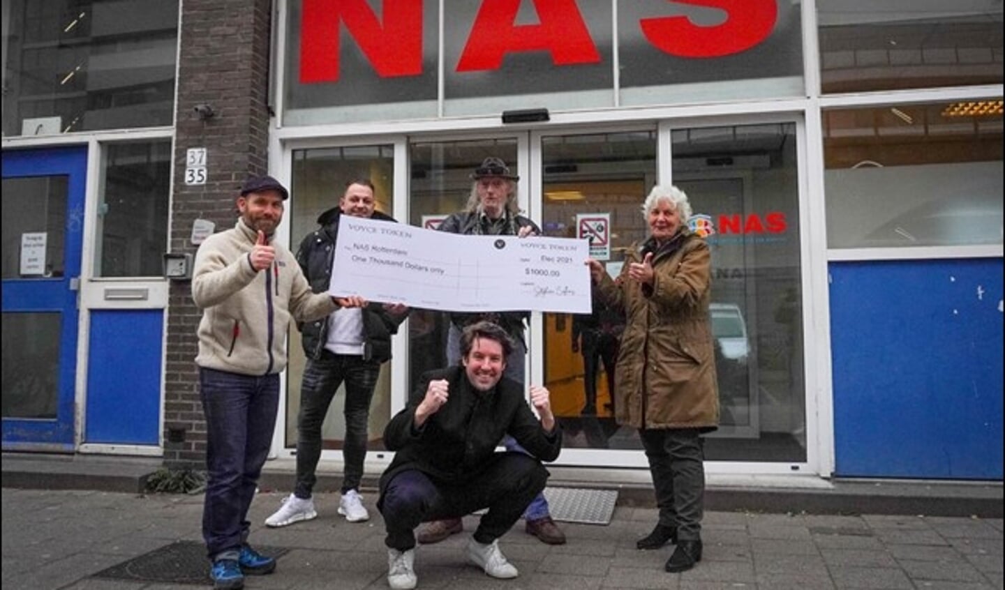 De uitreiking van een cheque van 1000 dollar aan daklozenstichting Nico Adriaans Stichting (NAS). Foto: pr