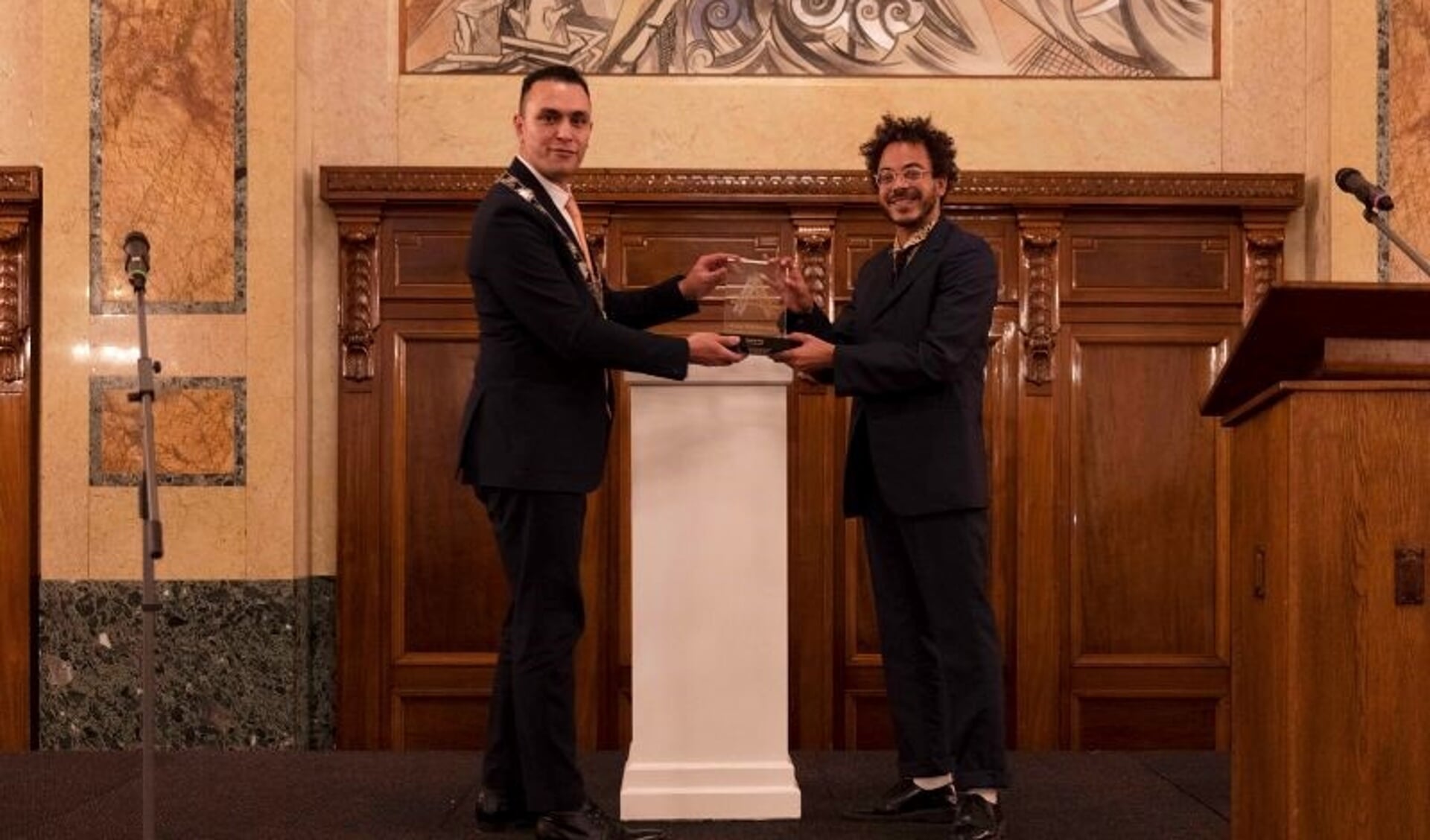 Locoburgemeester Faouzi Achbar overhandigde de prijs aan Raoul de Jong, een die de bekroning is van een waardevol auteurschap in en voor Rotterdam. Foto: pr