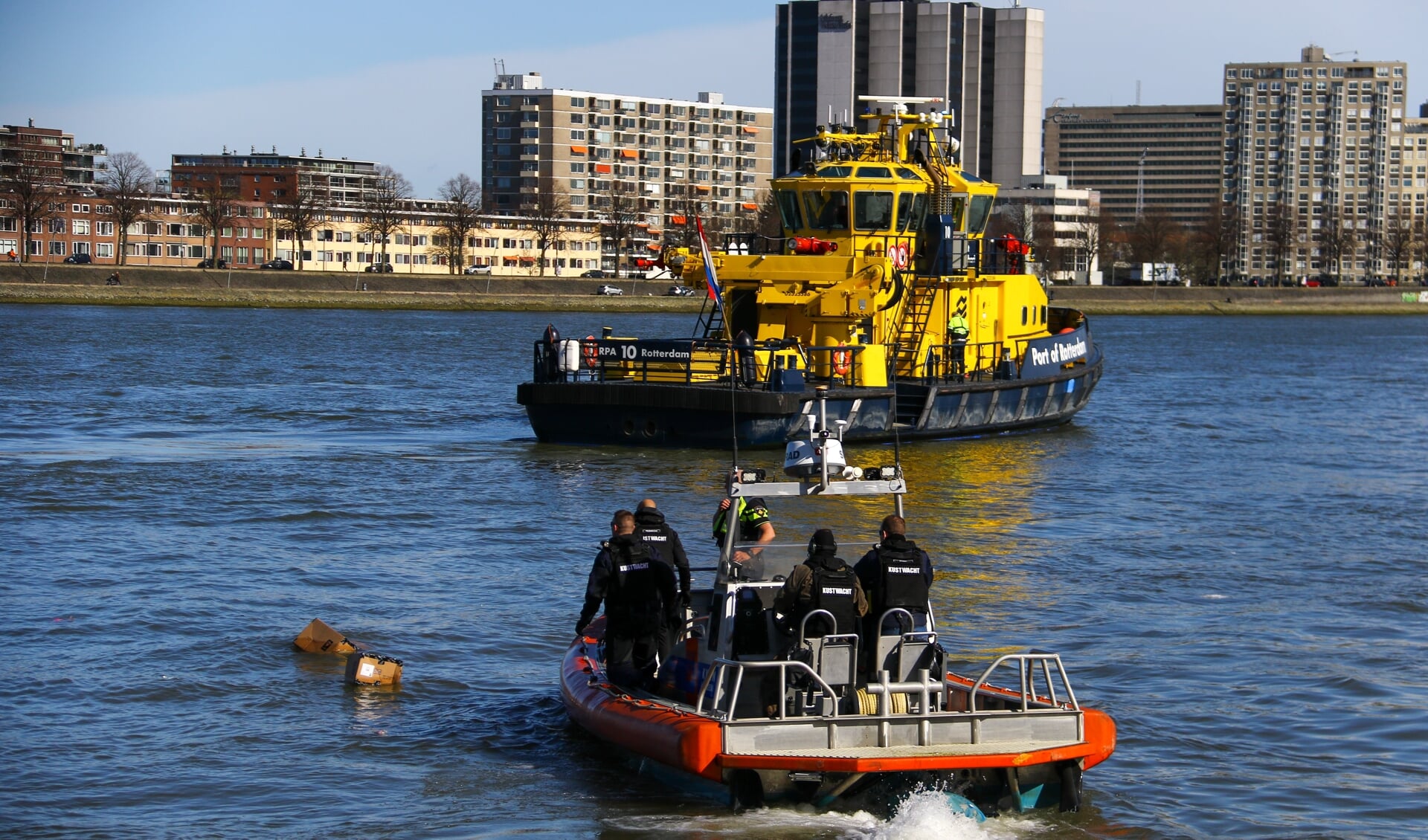 Een containerschip is tegen de Willemsbrug aangevaren waarbij twee zeecontainers in het water vielen. Er wordt geprobeerd om zoveel mogelijk dozen uit het water te halen. Foto's: GinoPress B.V.