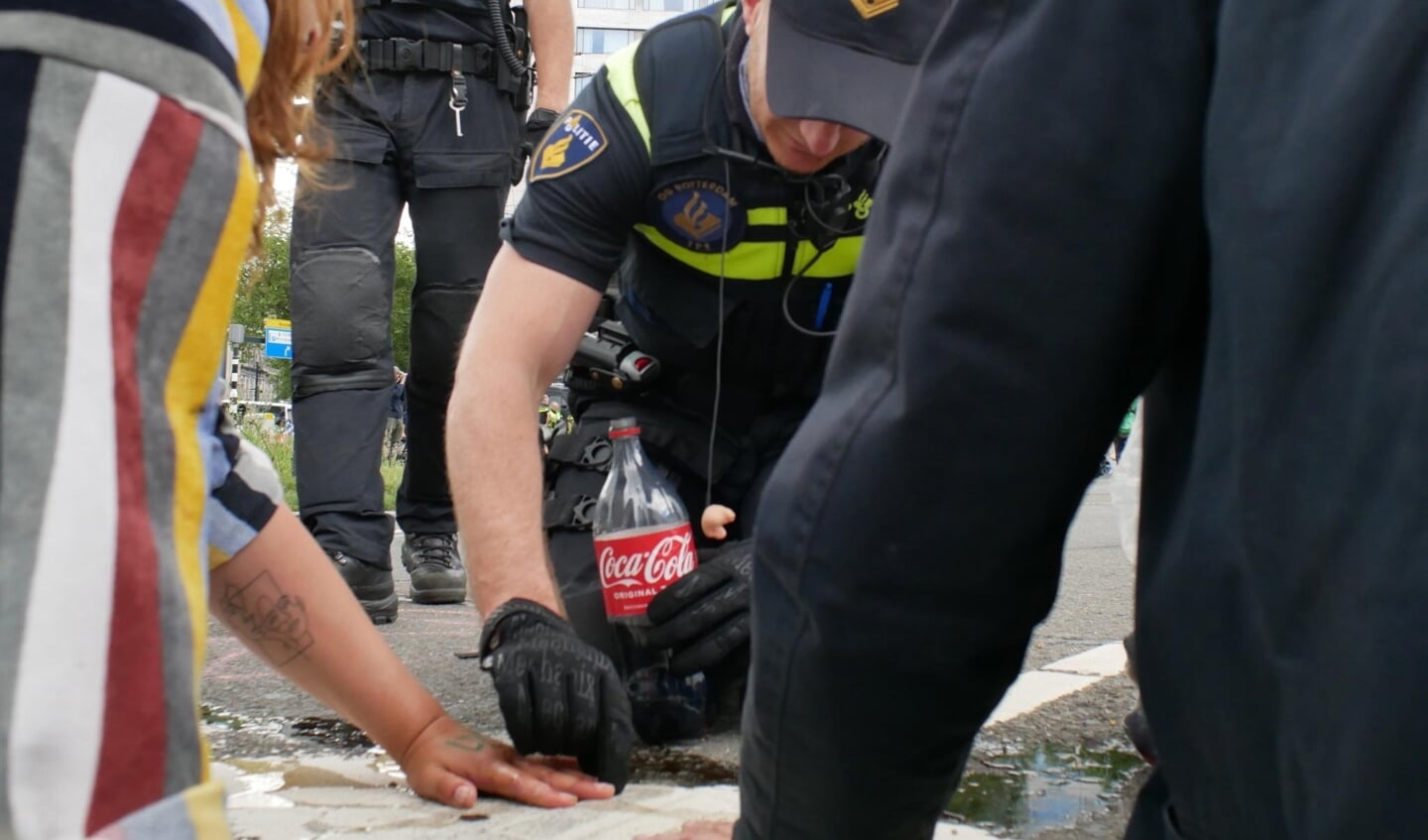 De politie gebruikt onder andere Cola om de actievoerders los te krijgen. Foto's: twitter