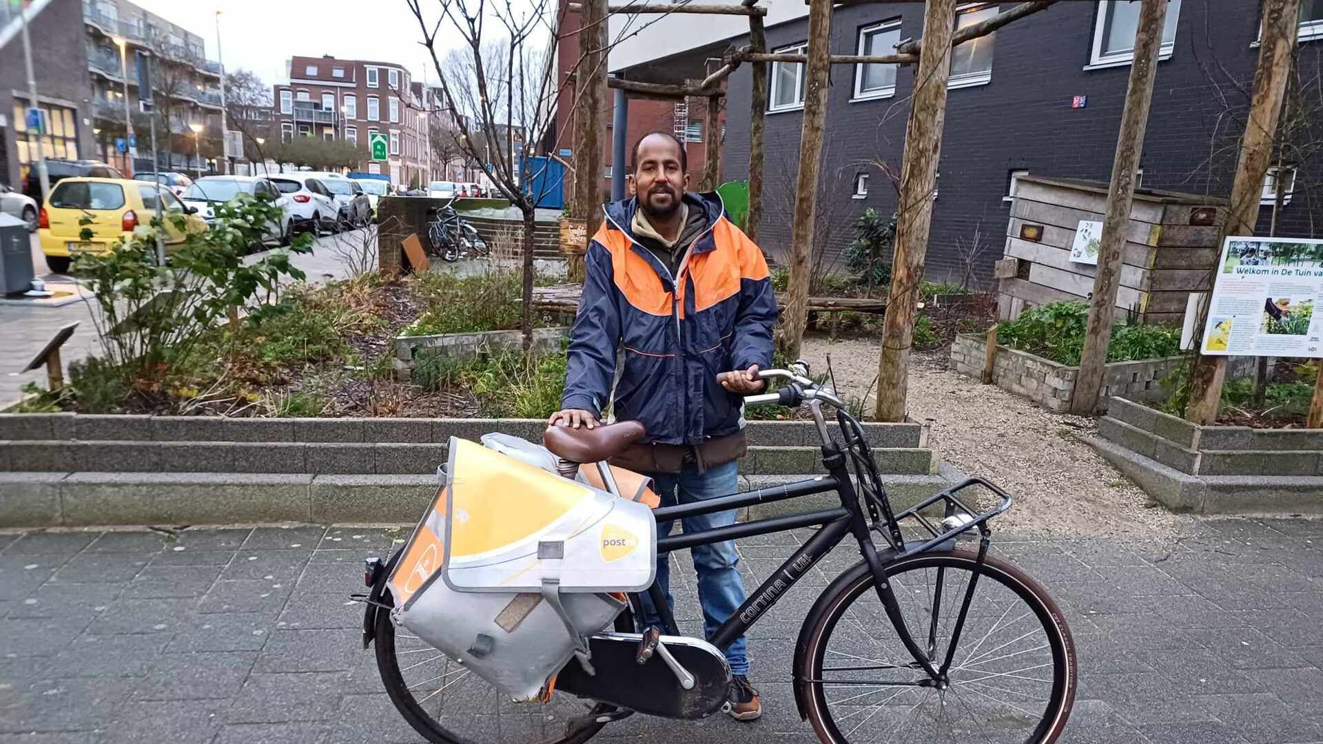 Ahmed Abdillahi met zijn postfiets. 'Ik werk als postbezorger én op het sorteercentrum, samen is dat een drukke fulltime baan.'