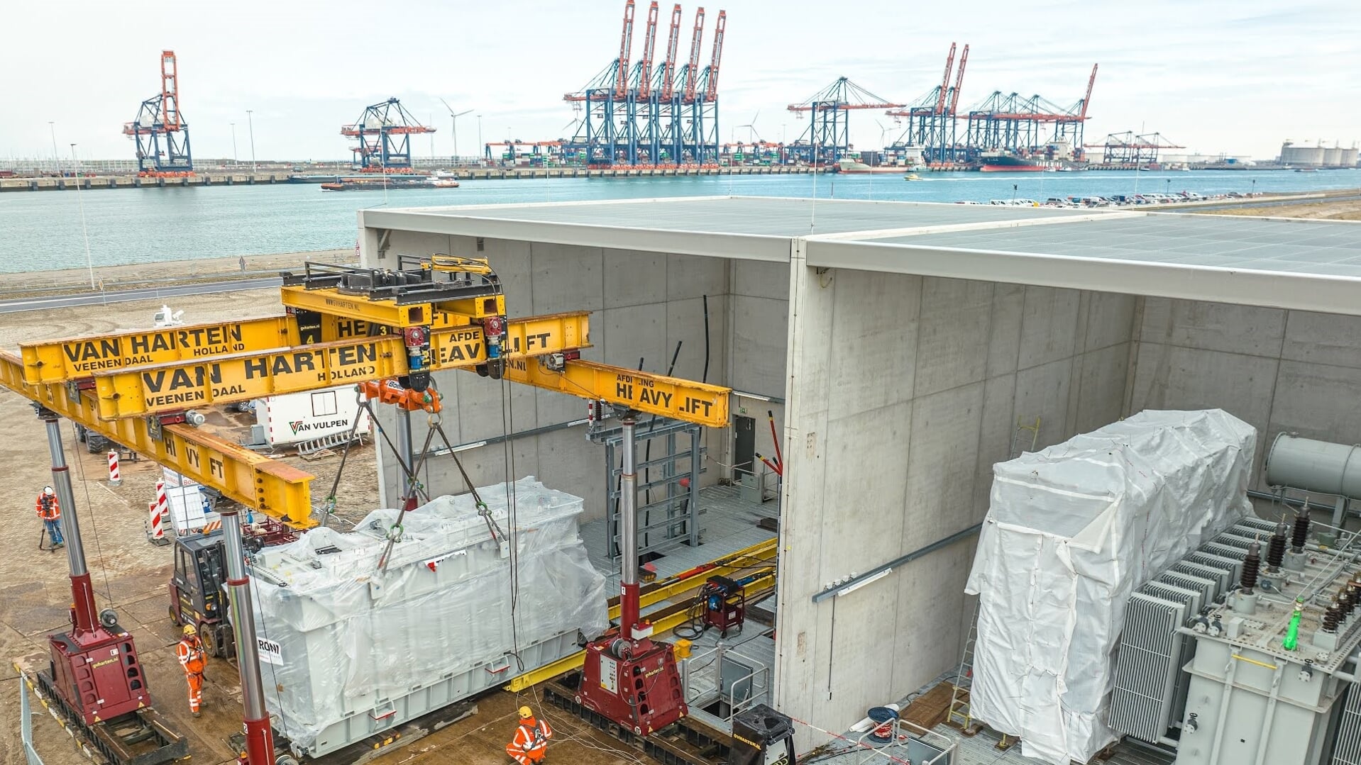 De transformator van 90 ton wordt op z'n plek gezet in het nieuwe verdeelstation van Stedin aan het Yangtzekanaal. Foto: pr