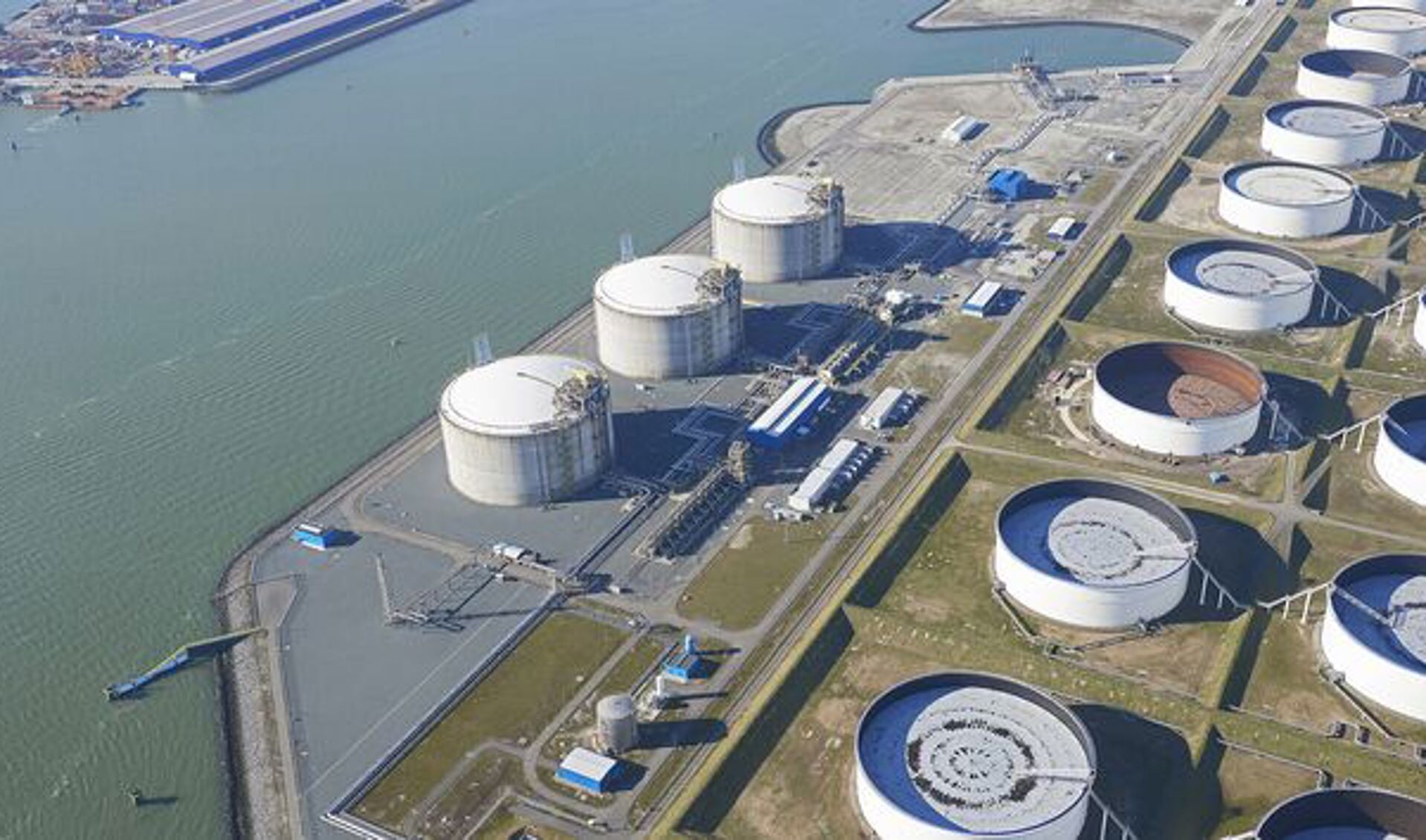 De drie grijze LNG-tanks bevinden zich naast de waterzijde - de 4e LNG-tank zal naast deze tanks worden gebouwd. Foto: Aeroview 
