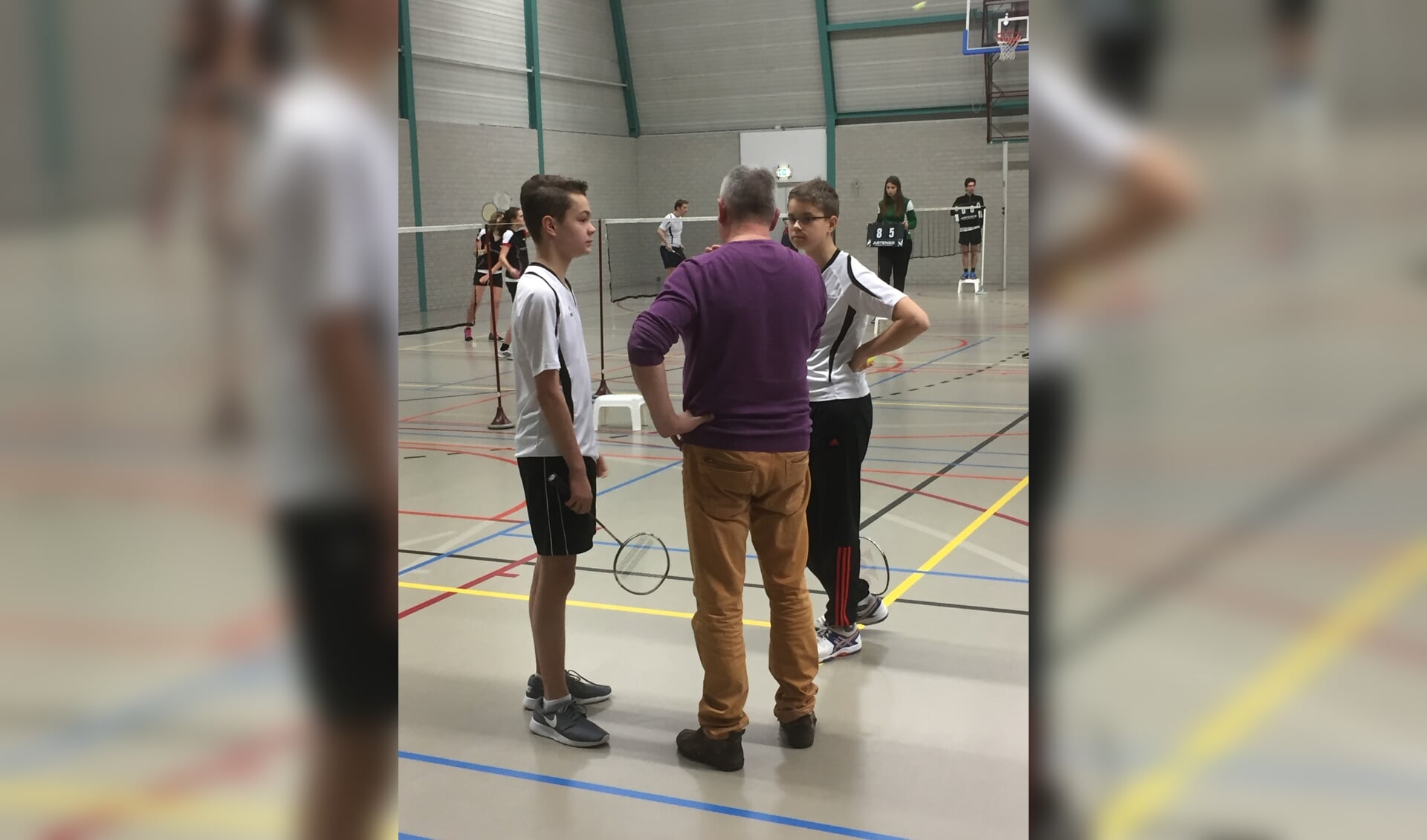 Trainer Frans van Waardenburg (midden) helpt Stijn Brouwers en Pepijn Kerkhof met wat tips voor in hun dubbelpartij