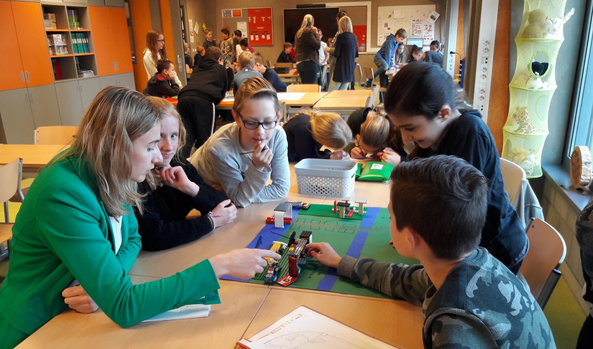 Mevrouw Hoeks (l) bespreekt met de kinderen de maquette