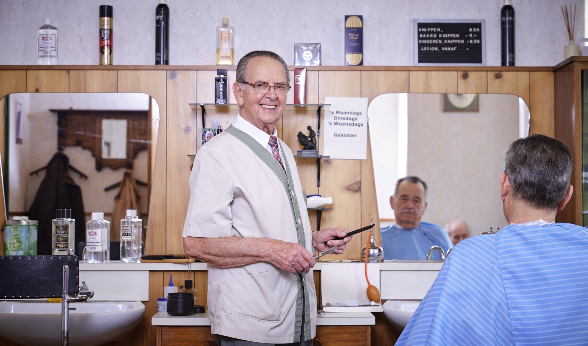 Kapper Tiny Donkers aan het werk in zijn kapperszaak