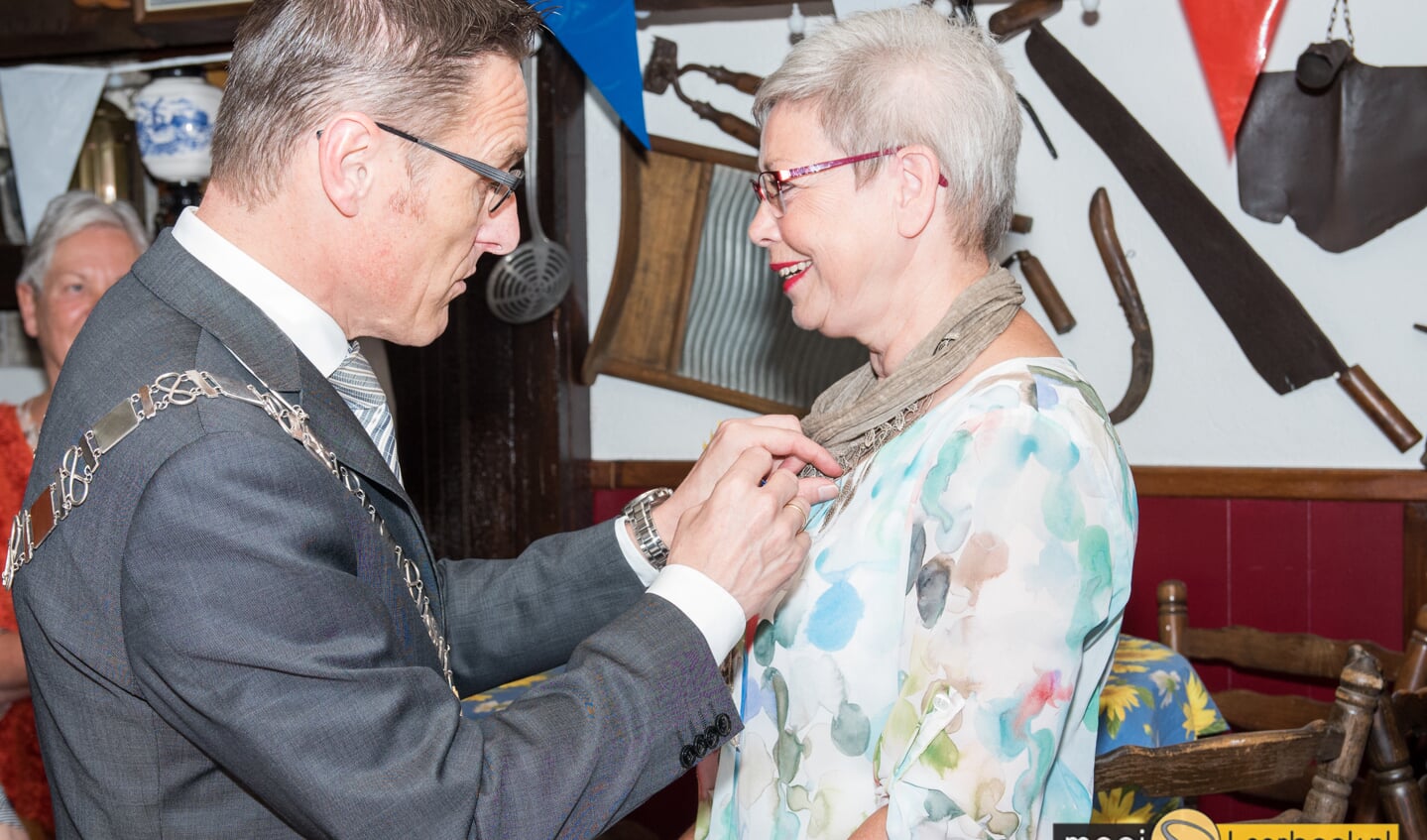Ria Dinnissen krijgt het lintje opgespeld door burgemeester Frank van der Meijden