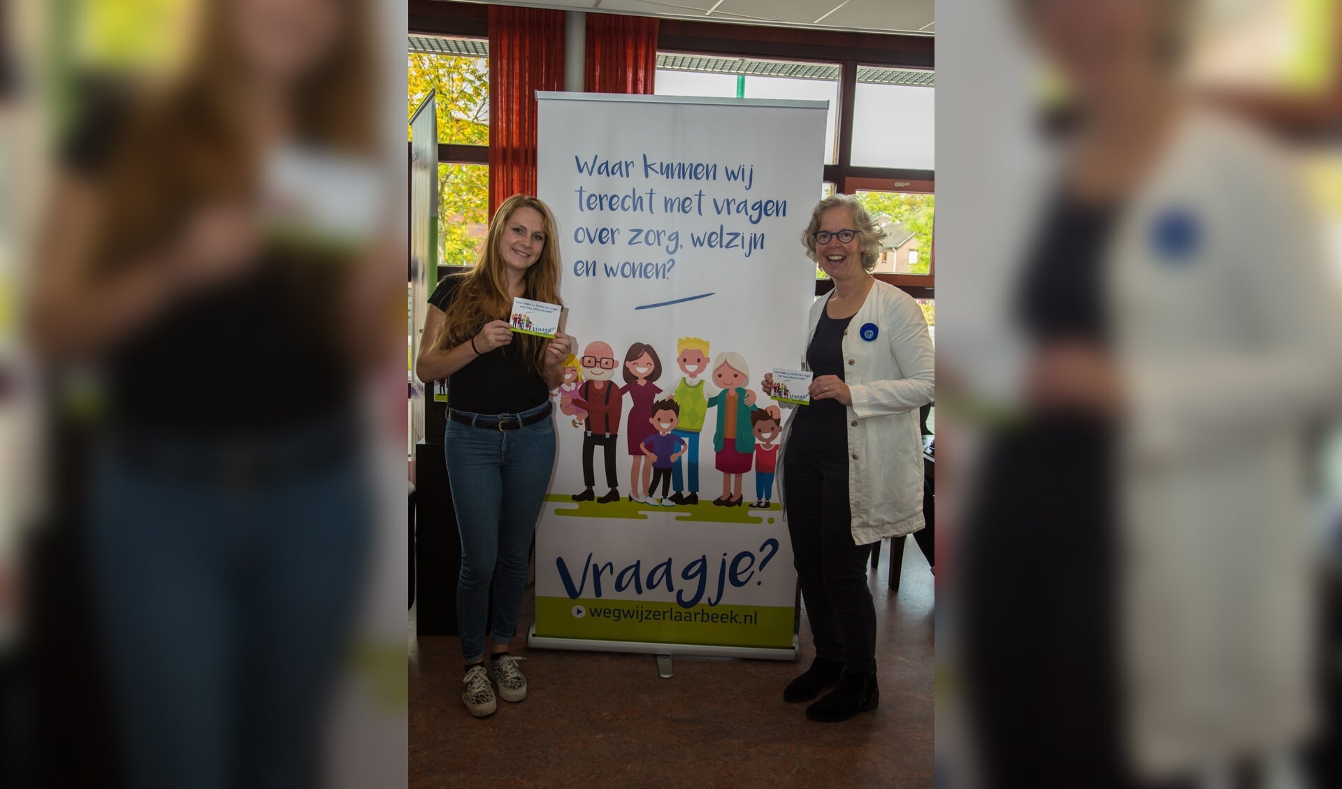 Nicky van de Ven van ViERBINDEN en Lydia Bongenaar van Gemeente Laarbeek bij de banner ter promotie van Wegwijzer Laarbeek tijdens de Dementievriendelijke Dag