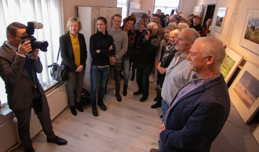 Burgemeester Frank van der Meijden (met camera) opent de foto-expositie van Marcel van de Kerkhof (Beek en Donk) en Marcel van de Kerkhof (Aarle-Rixtel)