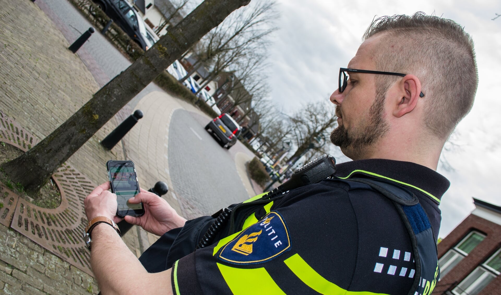 Wijkagent van Aarle-Rixtel, Roel Timmermans, bezig met de app van Nextdoor