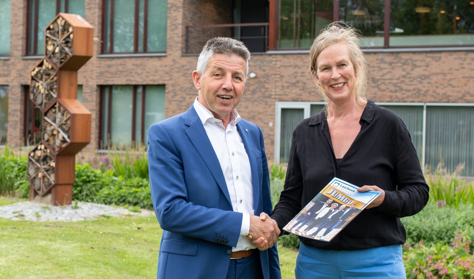 Hester Verduin (Laarbeek Media) reikt de derde editie van Laarbeek Onderneemt uit aan wethouder Tonny Meulensteen
