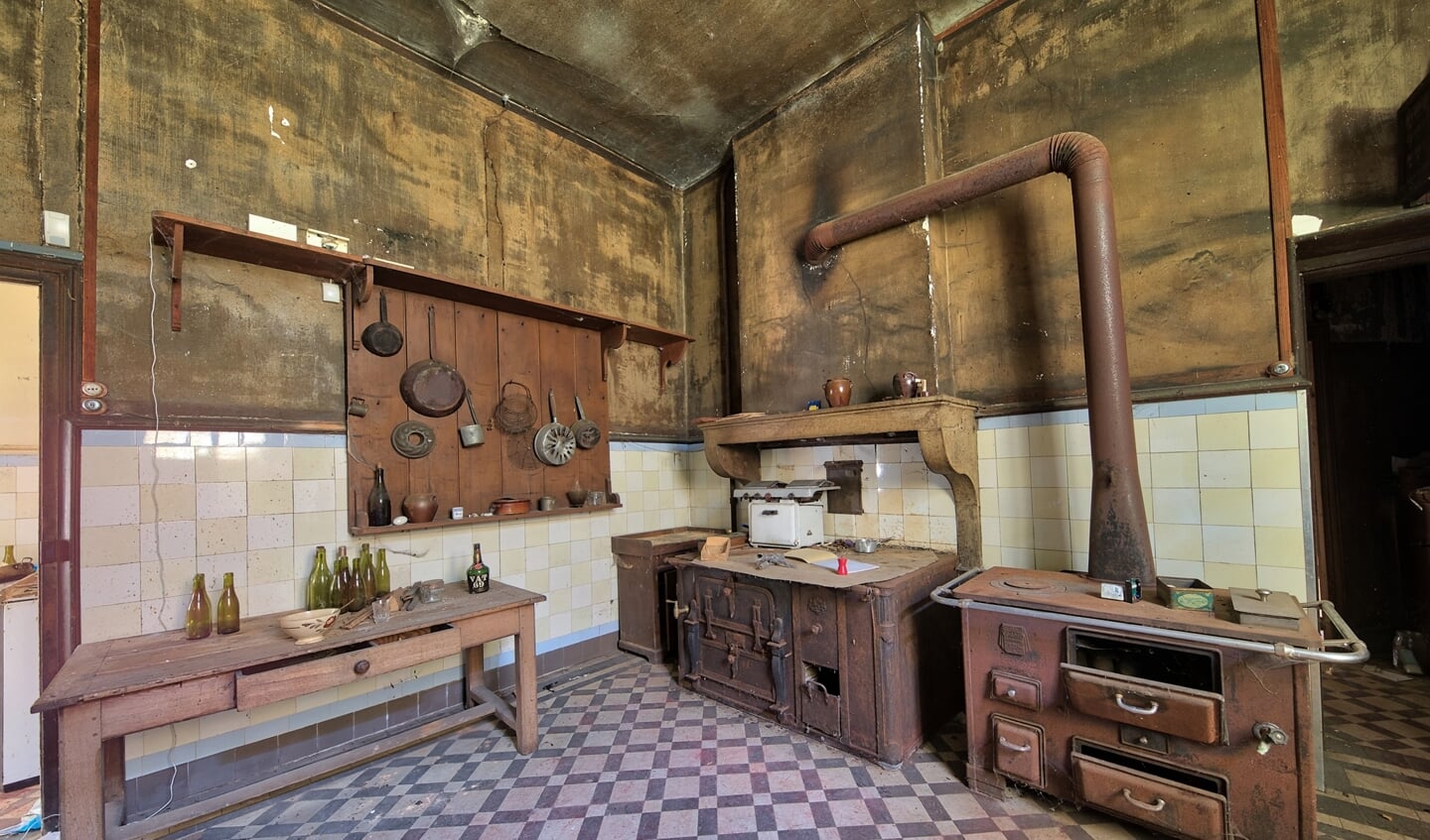 Een oude verlaten keuken, waar de pannen nog aan de muur hangen