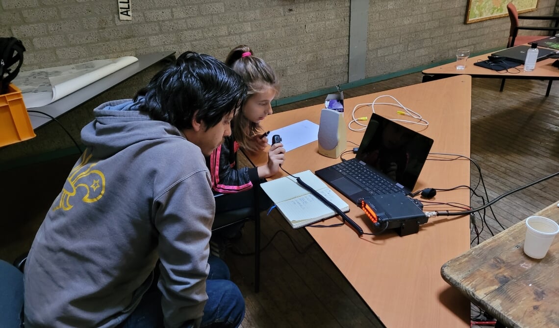 Een scout leert verbinding maken met andere groepen via de zender.