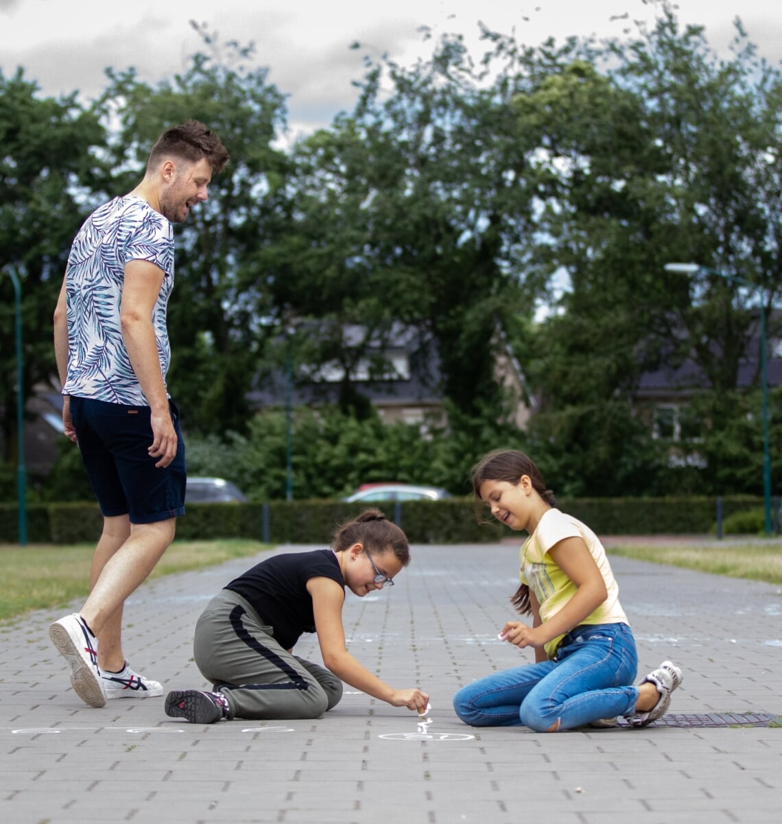 De leerlingen van Job Berkers (l) maken sommen op de stoeptegels