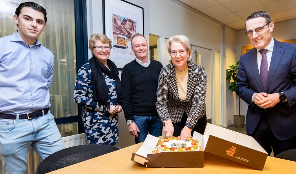 Jacqueline Vogels snijdt de taart aan. Rechts burgemeester Frank van der Meijden