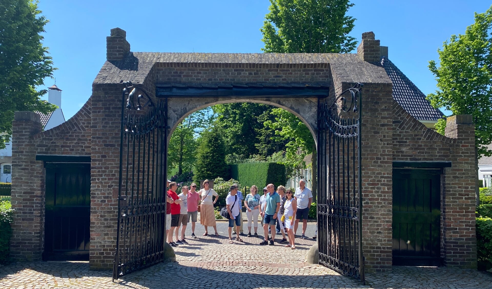 Een deel van de deelnemers bekijkt de Binderse poort die vanwege een verloren kaartspel ooit overgezet is van Helmond naar Lieshout.