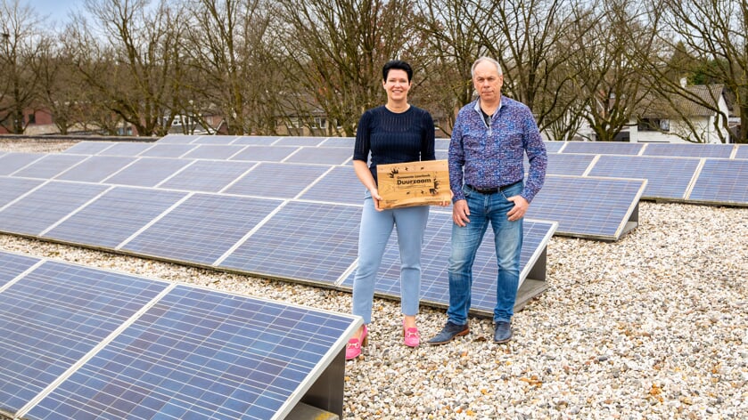 Wethouder Monika Slaets en Frans Rooijakkers bij de zonnepanelen op het dak van het gemeentehuis