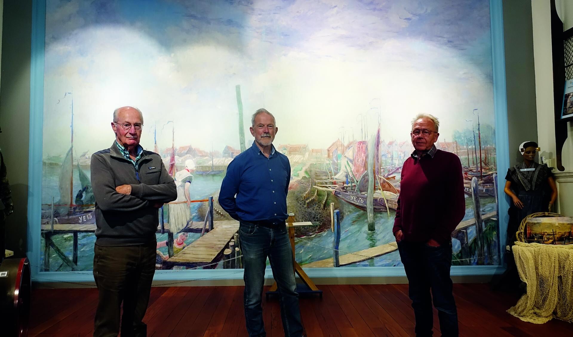 Voorzitter Adri Boone, Leo Pekaar en Adri de Koeijer bij het panoramaschilderij ‘Gezicht op de haven van Yerseke’, een van de blikvangers in het museum.