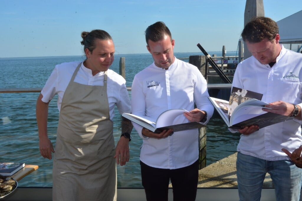 H Behalve de eerste opgeviste oesters kregen chefkoks Syrco Bakker, Thijs Meliefste en Wouter Kik (van links naar rechts) bij de officiële opening van het oesterseizoen ook Het Oesterboek overhandigd.