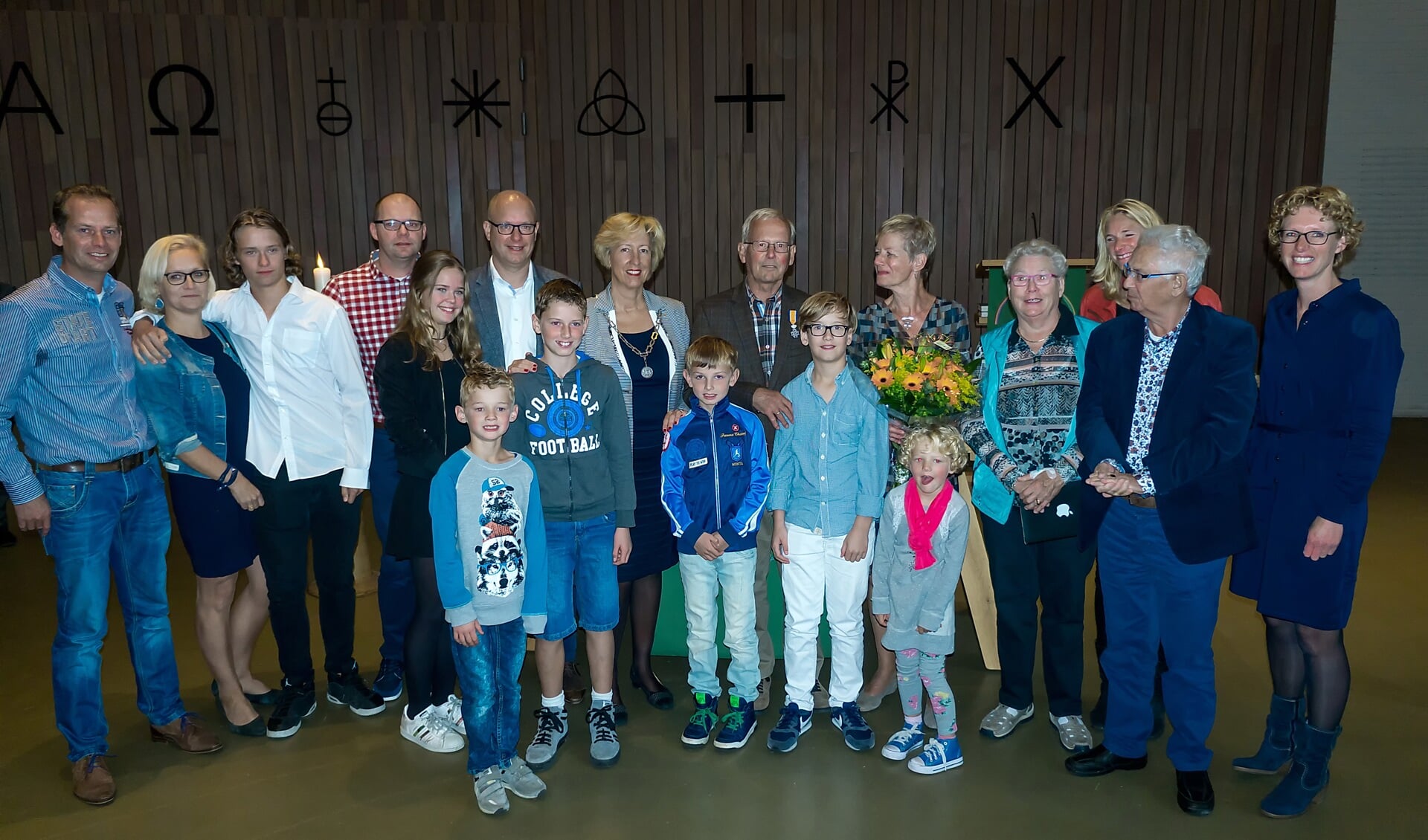 Joop Bakker staat tussen zijn echtgenote (met bloemen) en burgemeester Driessen en wordt omringd door zijn hele famlie. | Foto: J.P. Kranenburg