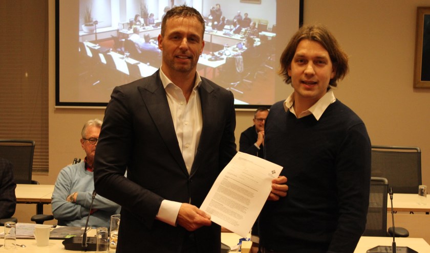 Raadslid Maarten van Welie (CDA) overhandigt het initiatiefvoorstel aan wethouder Bas Brekelmans (links). | Foto: Nico Kuyt