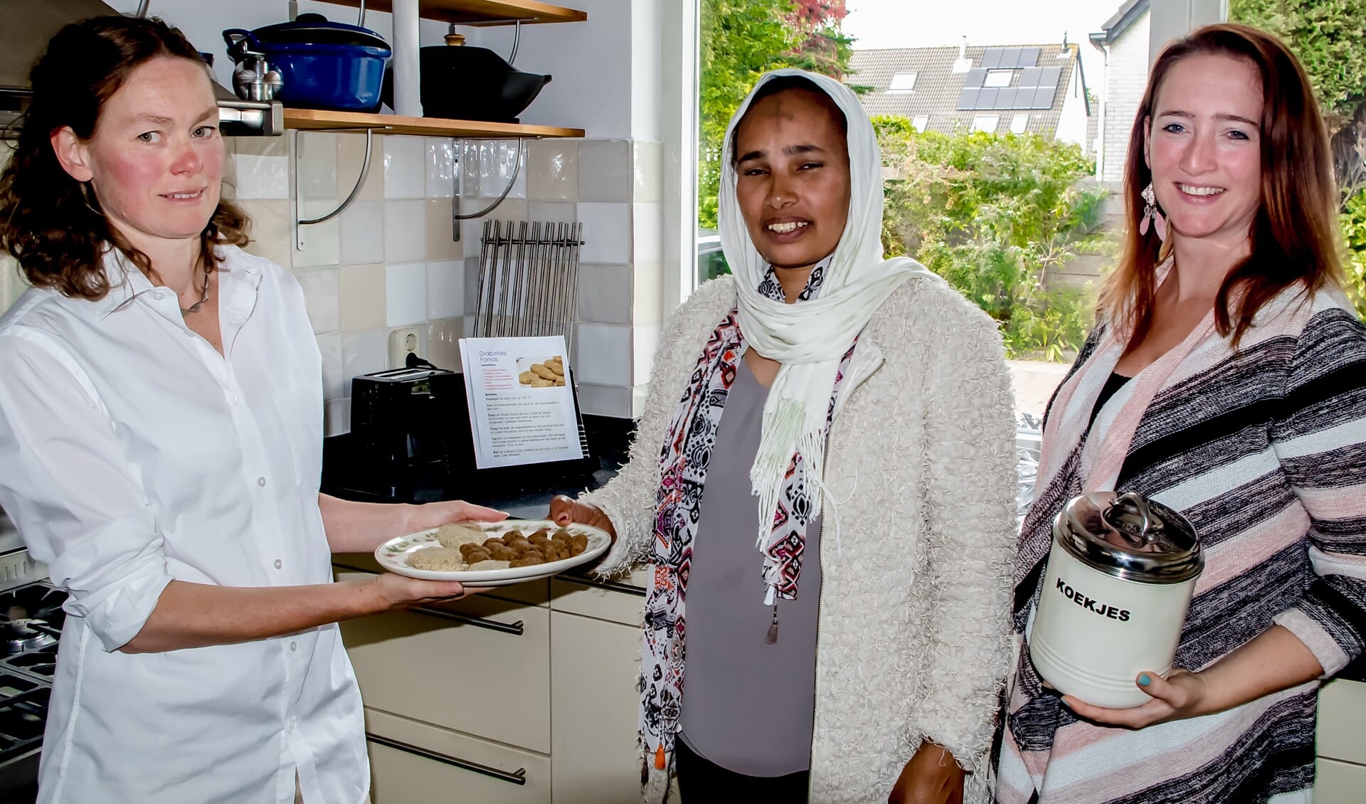 Maatje Millicent Kruis (links) heeft samen met Tsegeweni Zeru (midden) koekjes en pepernoten gebakken. 'Kleurrijk Leiderdorp' is een initiatief van Laila Konstapel (rechts). | Foto J.C. Kranenburg.