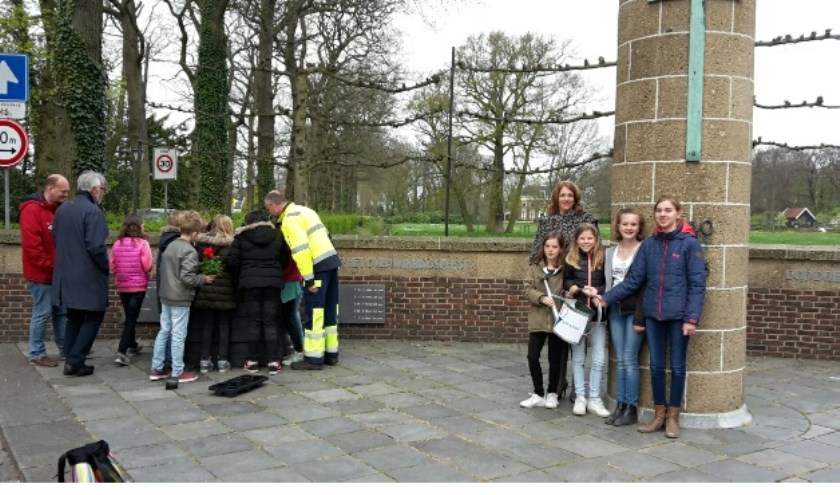 Leerlingen van Het Landtgoed dragen de gieter over aan die van De Waaier. Burgemeester Carla Breuer is ook bij de overdracht bij het monument aanwezig. | Foto: pr.  