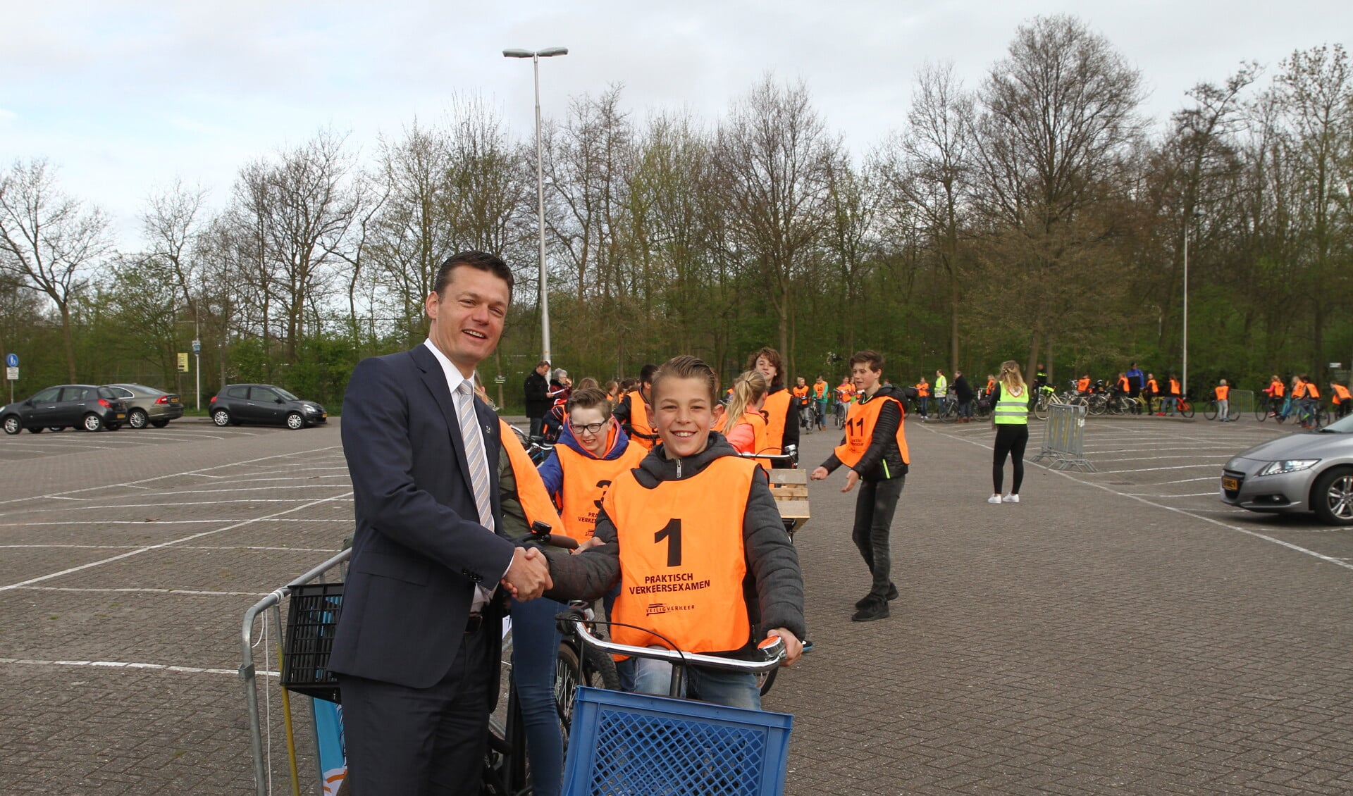 Met een ferme handdruk wenste wethouder Nieuwenhuis de eerste deelnemer aan het verkeersexamen succes. | 