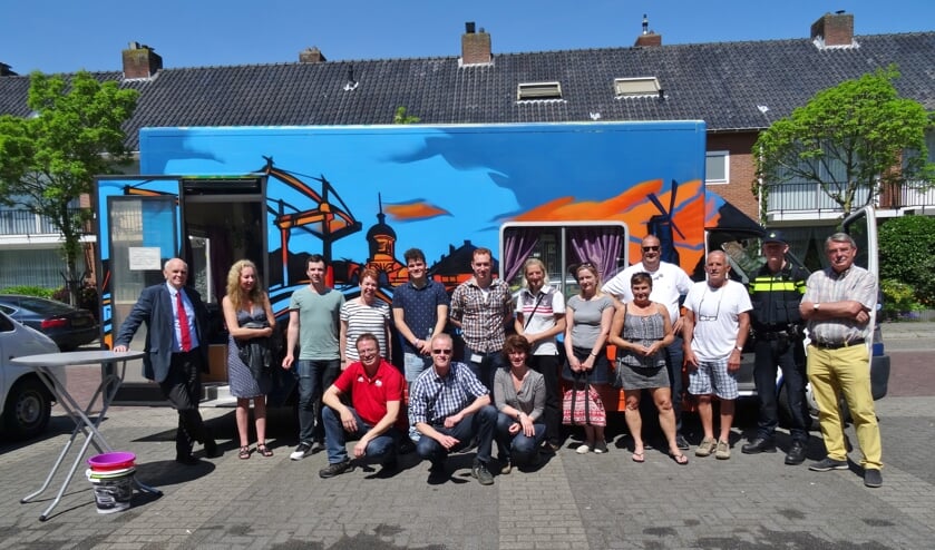 Oranjewijkbewoners en gemeenteambtenaren voor de nieuwe buurtbus, die zal dienen als verzamelpunt bij de wijkwandelingen.   