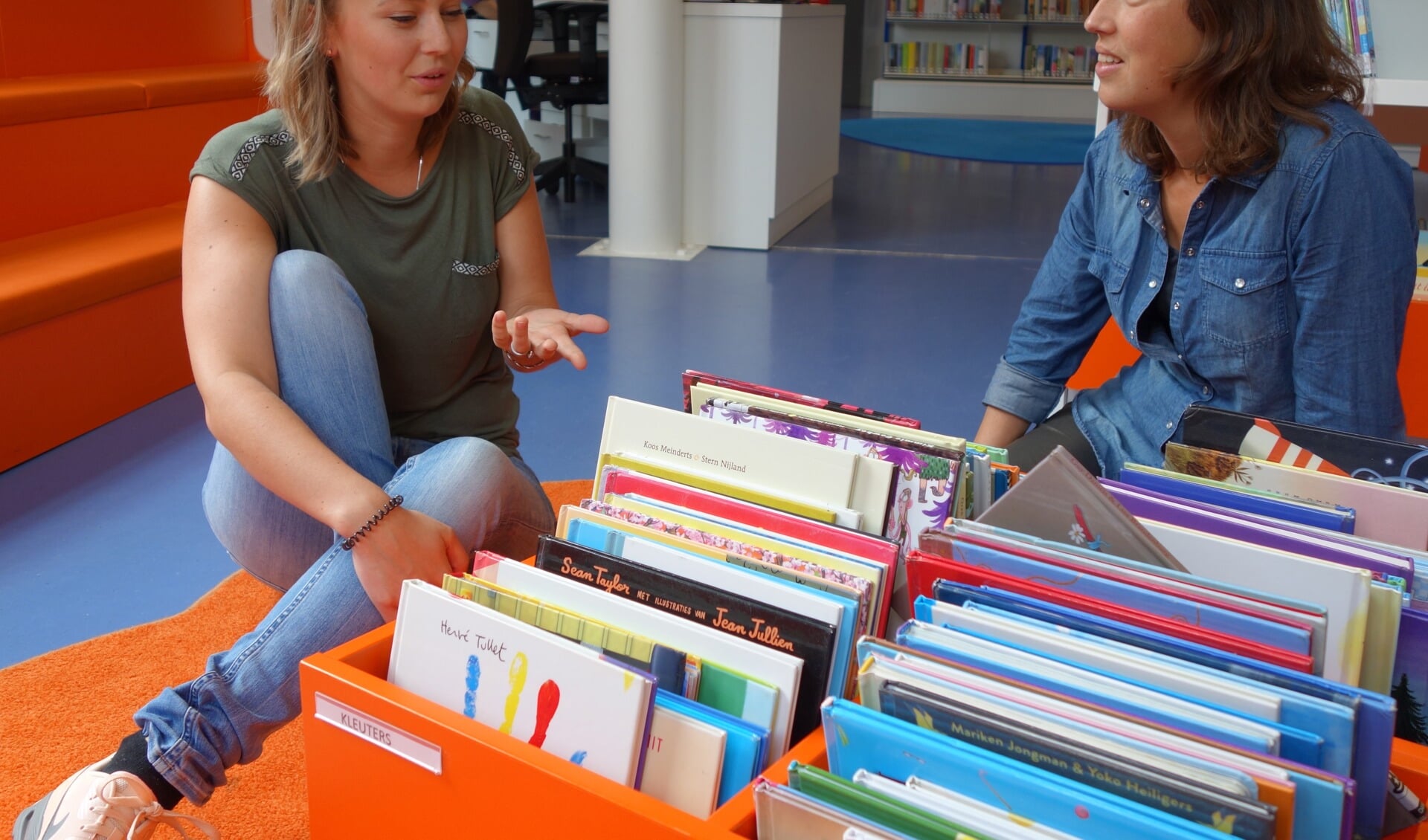 Anneke Janssen (25) en Hannerieke Dekkers (38) praten in de kleurrijke bibliotheek van Warmond enthousiast over hun vrijwilligerswerk bij de VoorleesExpress. 
