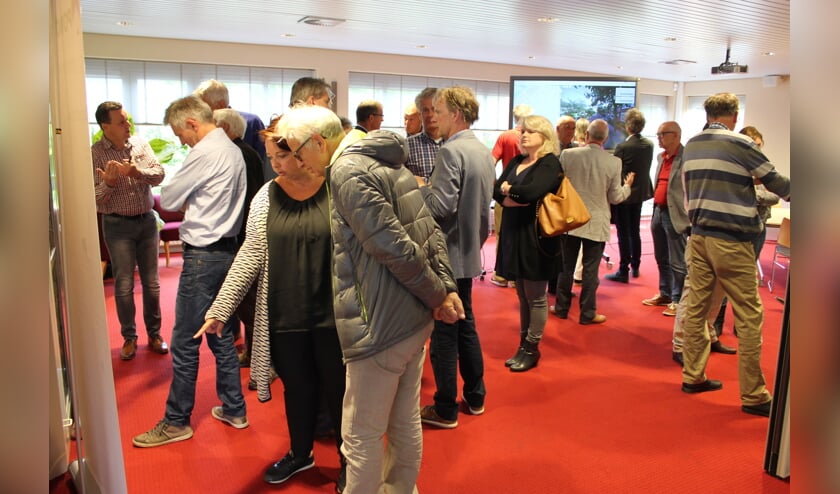 Bezoekers van de informatiemarkt in het Bestuurscentrum bekijken de informatie over windmolens bij AkzoNobel. | Foto: Nico Kuyt