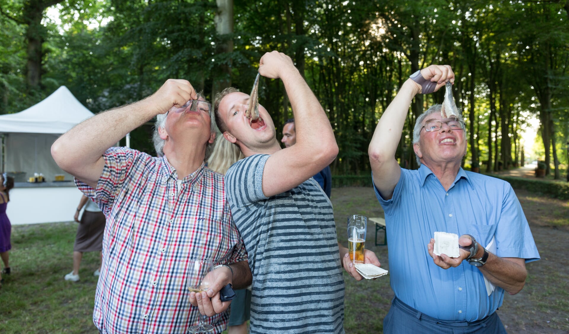 Wim van Tuijl (rechtss) proeft haring samen met rasondernemers vader en zoon Wiegel. | Foto Wil van Elk