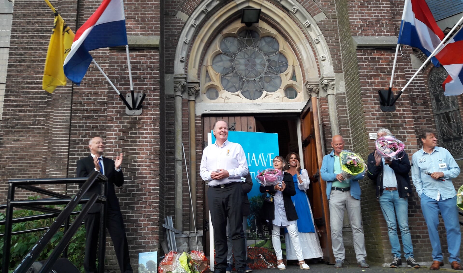 Jan Mosselman wordt na afloop van de boekpresentatie geridderd door wethouder Arno van Kempen (l) en daarna door het publiek toegejuicht. | Foto: pr.