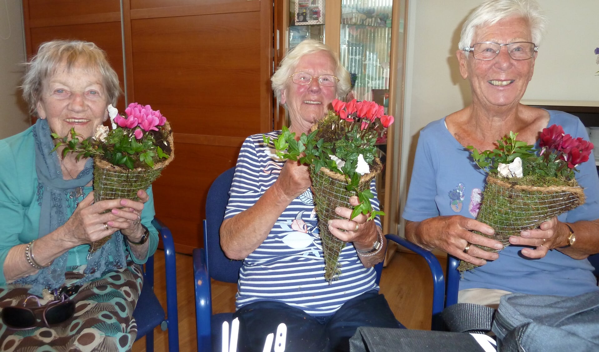 Drie van de deelneemsters tonen de groendecoratie die ze hebben gemaakt onder leiding van Gerda Bal. | Foto: Esta Hoogervorst