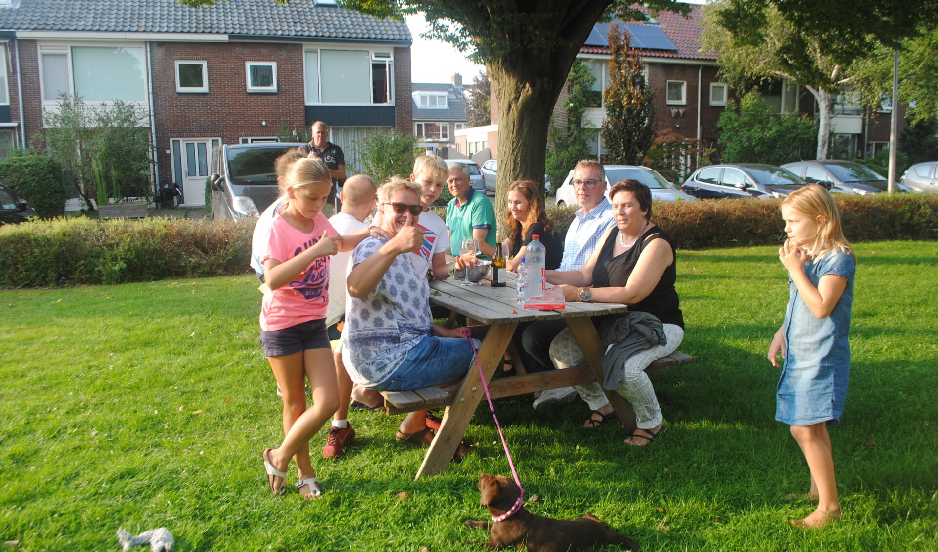 Gezellig met de buren napraten over de vakantie op het grasveld van het plantsoen in de straat.