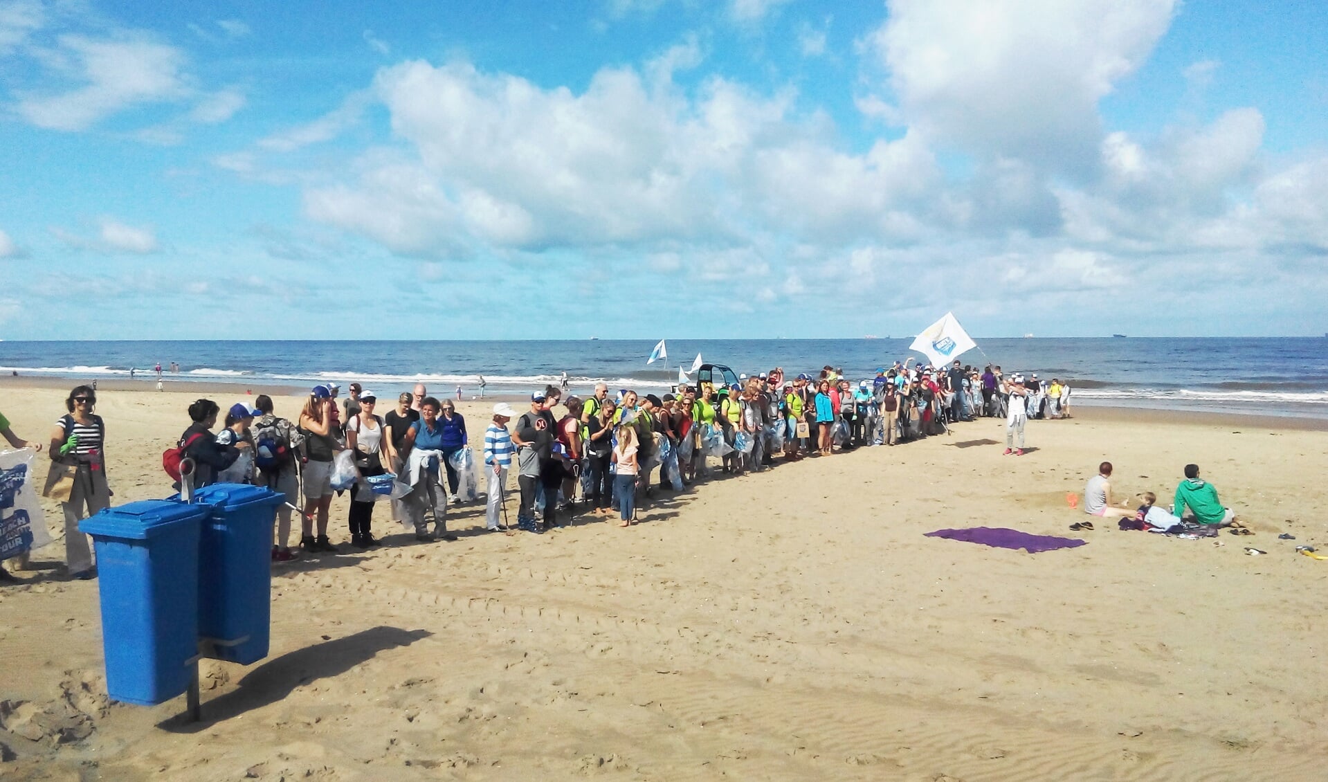De deelnemers staan klaar om na een lunch op het zuidstrand van Katwijk weer verder te gaan met hun schoonmaakactie. | Foto: Stichting de Noordzee
