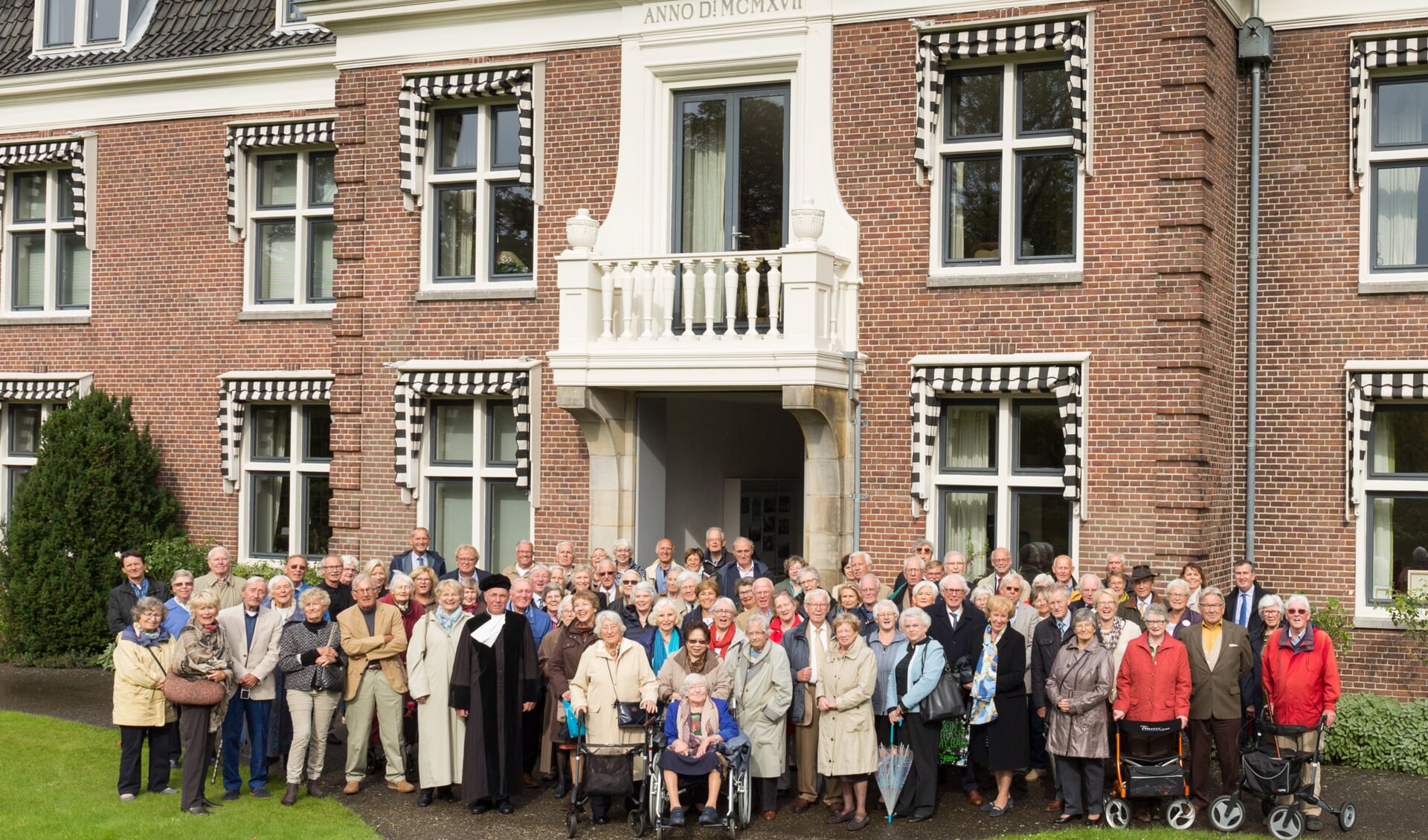 Inwoners en gasten poseren voor het honderdjarige Zendingshuis. | Foto Wil van Elk.