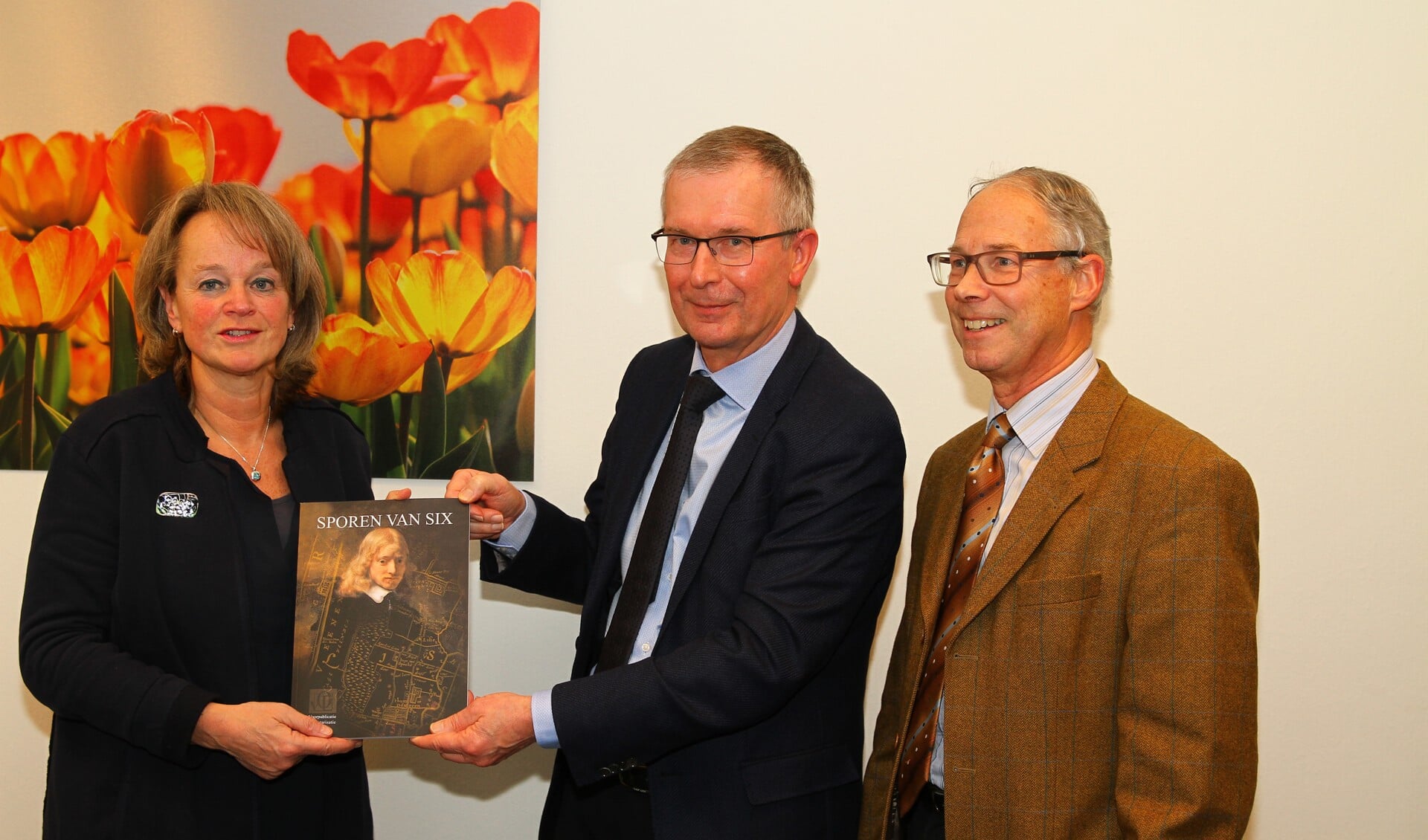 Vol trots presenteert Henk Schaap (midden), geflankeerd door voorzitter Eric Prince, het boek Sporen van Six aan burgemeester Spruit. 