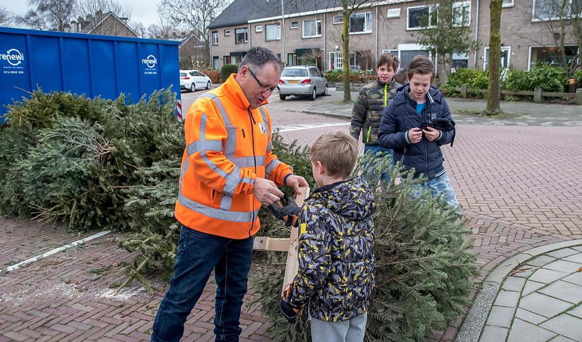 Een jongen krijgt uitbetaald voor de ingeleverde kerstbomen. 