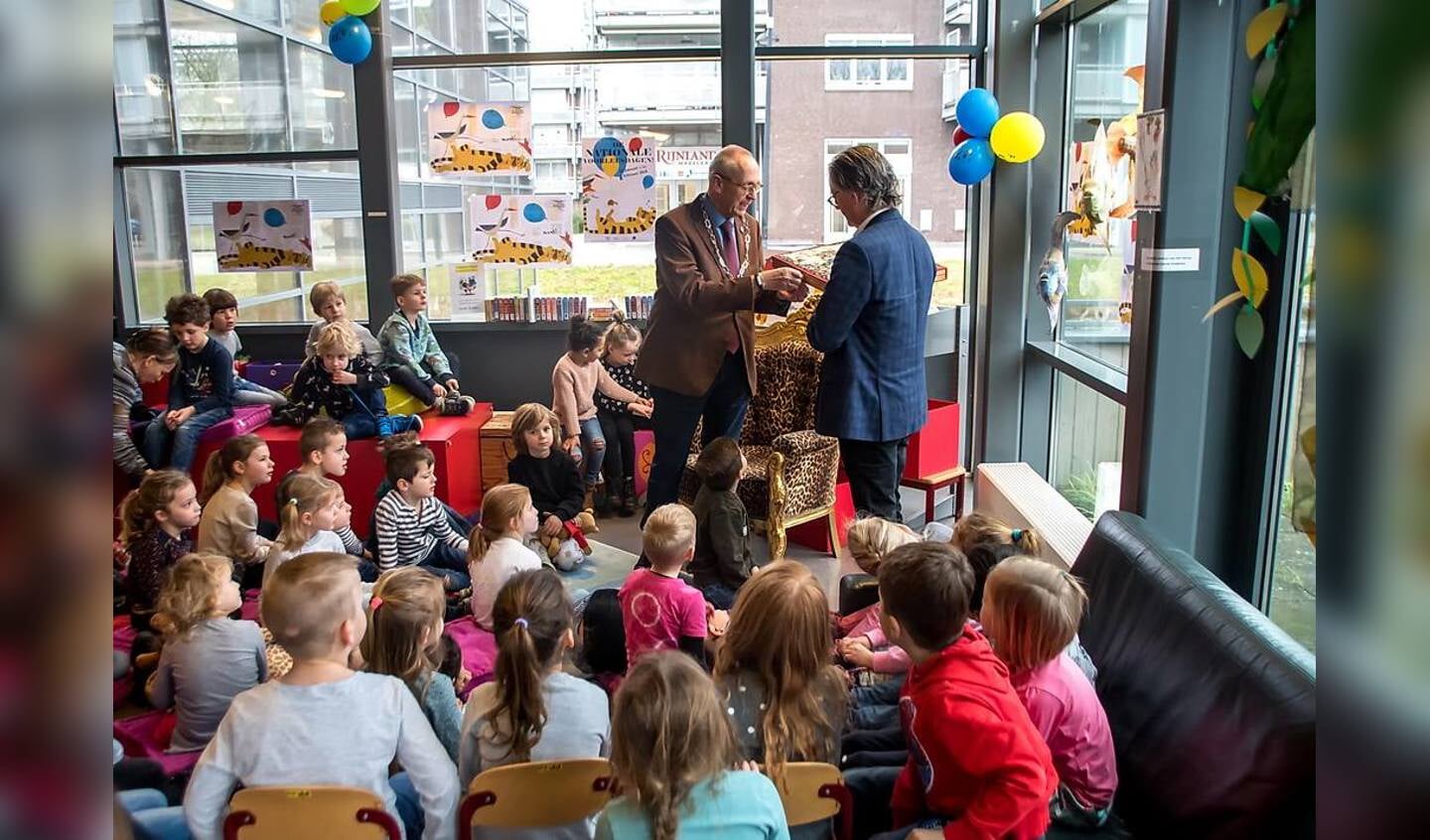 Kees Wassenaar krijgt het prentenboek 'Antonia' uit handen van Willem van Moort, voorzitter van de raad van bestuur van BplusC. 