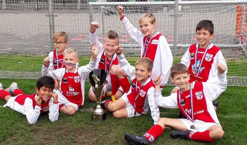 De toernooiwinnaars met hun grote gouden beker.