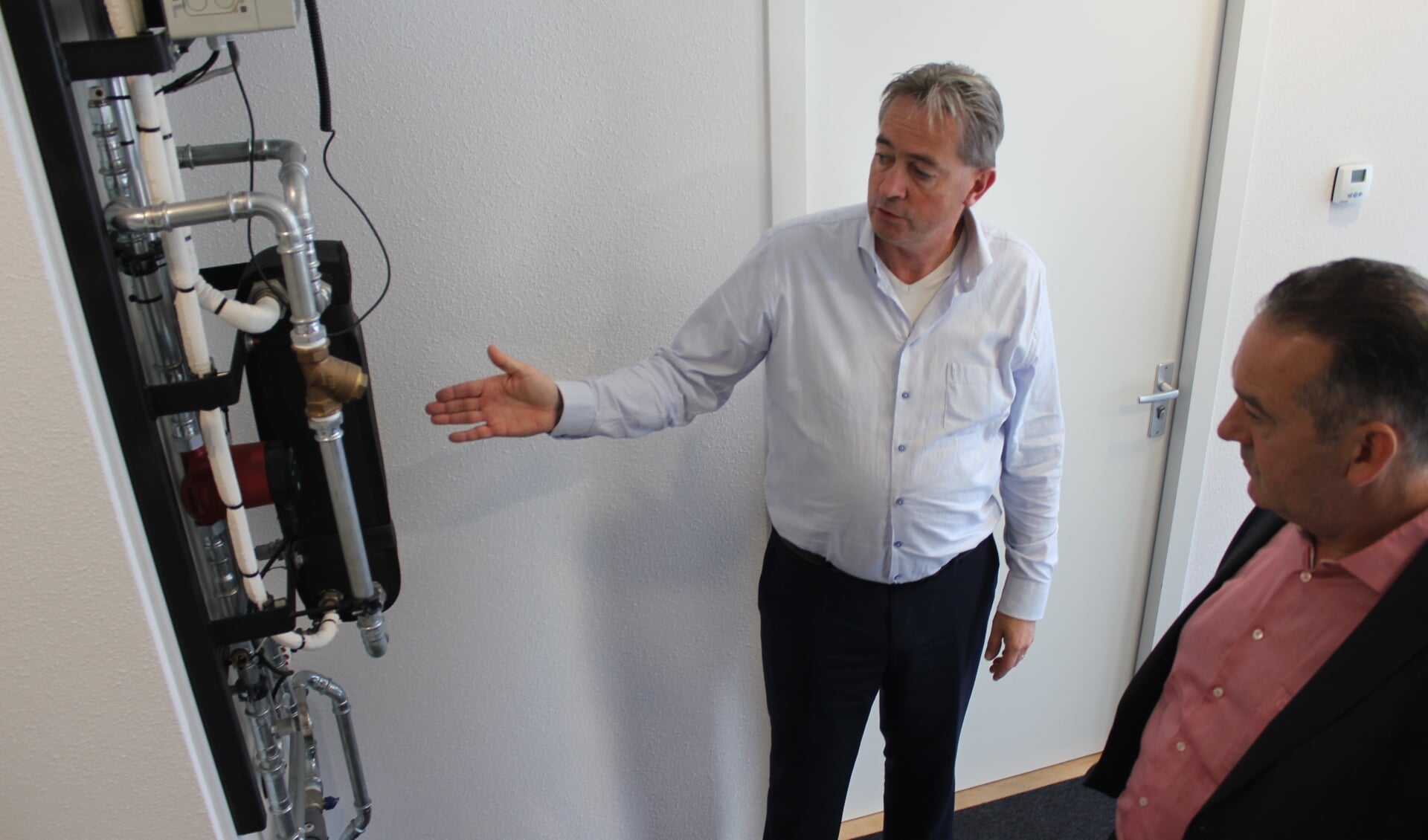 Wethouder Rob ten Boden bekijkt met eigenaar Homan van het bedrijf Fore de opmerkelijke energiezuinige installatie voor de regeling van warmte. | Foto: NK