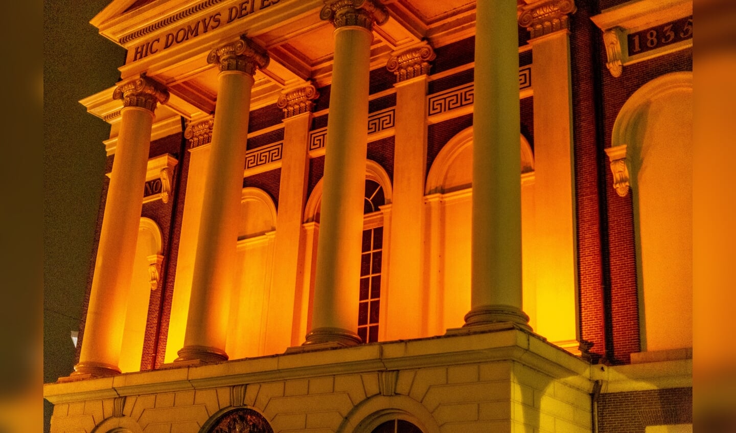Op de witte gevel van de Hartebrugkerk komt het oranje licht mooi uit. 