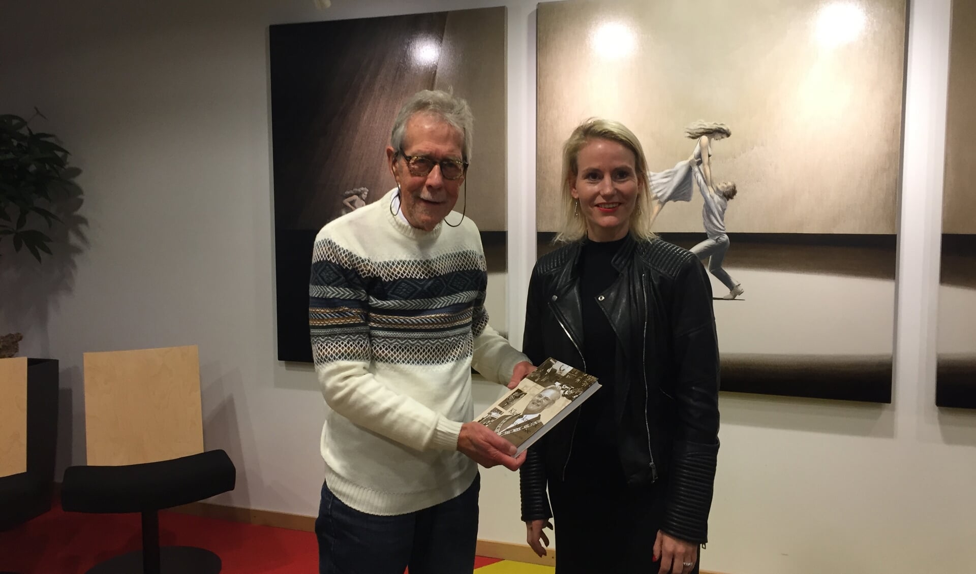 Met trots presenteert Arie zijn vierde kleine kroniek van Lisse aan wethouder Jeanet van der Laan. 