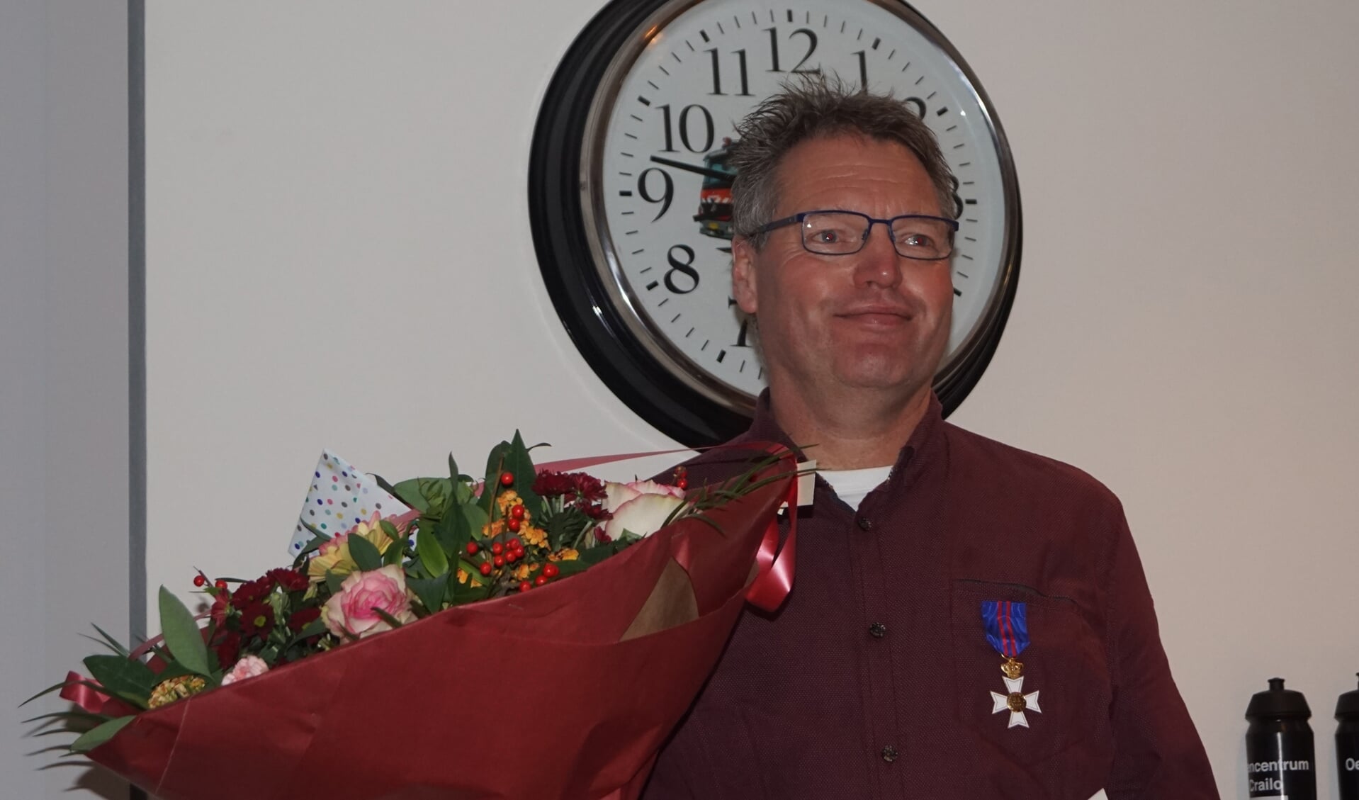 Christian van der Klauw met bloemen en oorkonde.